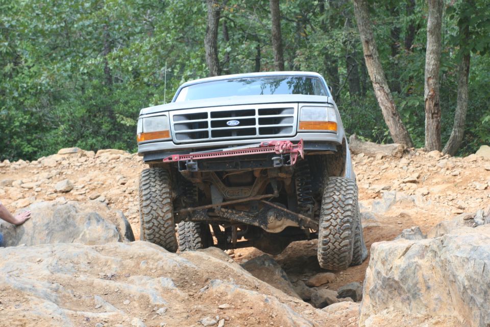 White Ford Bronco navigating rocky terrain, front view