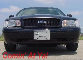 2003 Ford Crown Victoria - This black 2003 Ford Crown Victoria Police Interceptor is shown from the front, its distinctive grille and "Police Interceptor" badging.