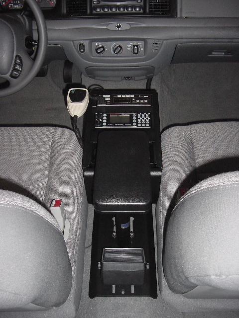 2003 Ford Crown Victoria - The interior of a 2003 Ford Crown Victoria, a police radio and center console between the front seats.