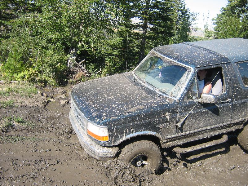 Dark 1995 Ford Bronco stuck in mud, front 3/4 view