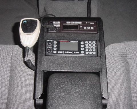 2003 Ford Crown Victoria - Close-up of police radio equipment, including a Motorola microphone and Uniden radio, installed in a vehicle's interior.