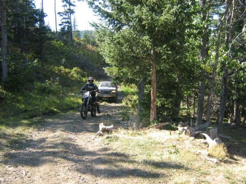 1995 Ford Bronco - A 1995 Ford Bronco is seen on a dirt road, with a dirt bike rider approaching.
