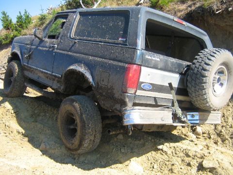 1995 Ford Bronco - This 1995 Ford Bronco is shown in a rear 3/4 view while navigating a dirt hill during an off-road excursion.