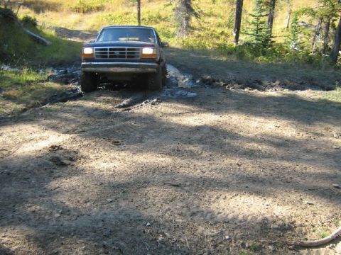 1995 Ford Bronco - This 1995 Ford Bronco navigates a muddy trail in a wooded area.