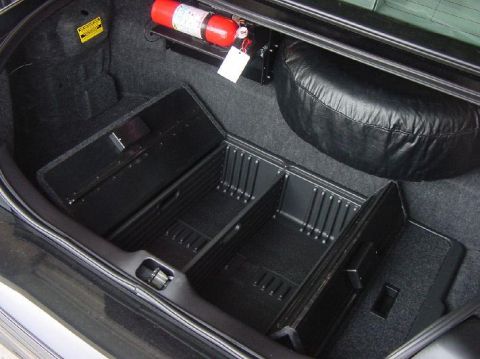 2003 Ford Crown Victoria - Trunk interior features organizer bins, a spare tire, and a mounted fire extinguisher.