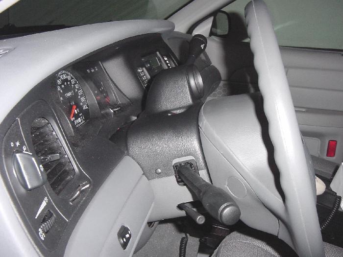 Vehicle interior showing gauge cluster, steering column shifter, and column-mounted pod in gray/black trim