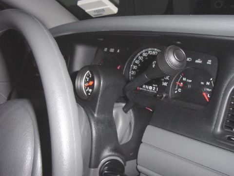 2003 Ford Crown Victoria - Interior view showing a steering wheel, dashboard, and an aftermarket gauge installed.