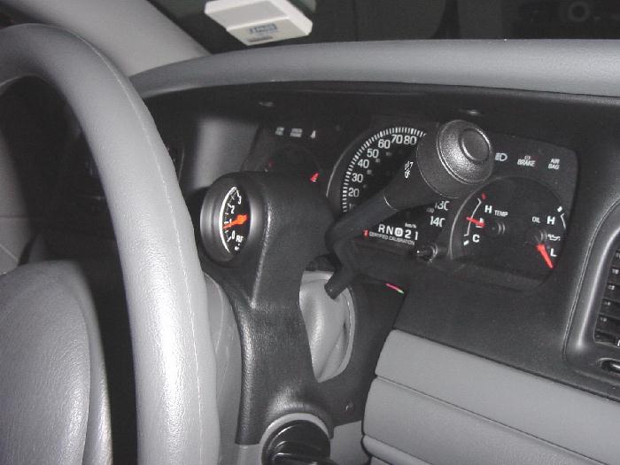 Car dash with speedometer, gauges, and aftermarket gauge in a black column pod