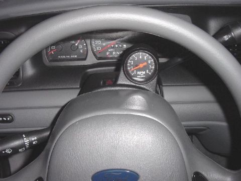 2003 Ford Crown Victoria - Interior view of a 2003 Ford Crown Victoria, the steering wheel and dashboard with an added tachometer.