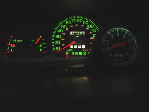 2003 Ford Crown Victoria - The illuminated dashboard gauges show the vehicle's speed, fuel level, voltage, and RPM, with the odometer displaying 011501.