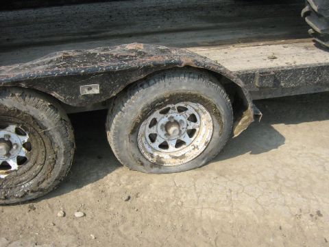 1995 Ford Bronco - This trailer has two flat tires, one of which is completely deflated.