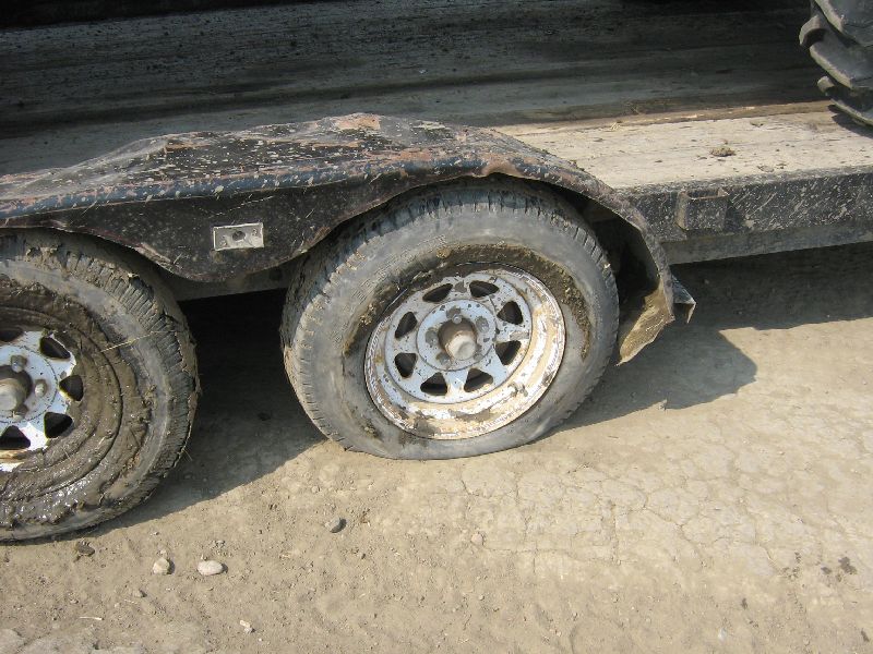 trailer with flat tires, one tire is completely flat