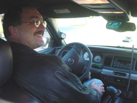 2003 Ford Crown Victoria - Driver's perspective inside a 2003 Ford Crown Victoria, showing the steering wheel, dashboard, and gear shifter.