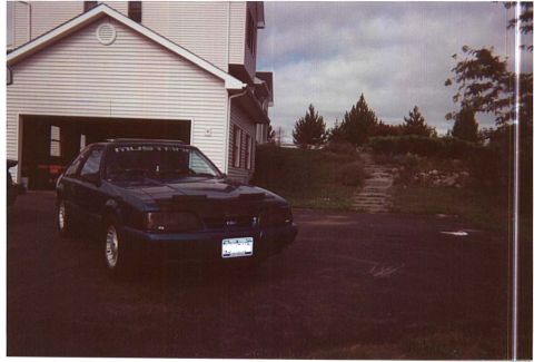 1990 Ford Mustang - This 1990 Ford Mustang coupe is parked in a driveway next to a house.