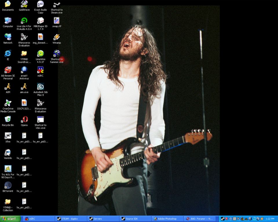 Man with long hair playing a sunburst electric guitar on stage