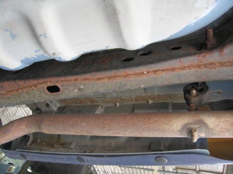 1991 Ford LTD Crown Victoria - Underside view of a vehicle's frame and exhaust pipe, showing rust and some blue paint.