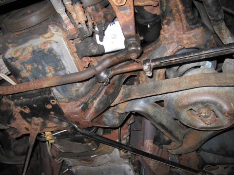 1991 Ford LTD Crown Victoria - This image shows the heavily rusted underside of a vehicle, focusing on suspension and engine components like tie rods and the oil pan.