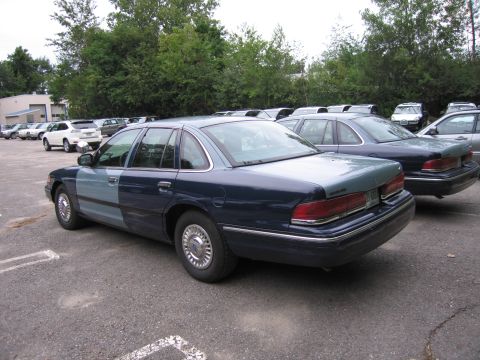 1991 Ford LTD Crown Victoria - Ford Crown Victoria with mismatched paint panels is parked next to another Crown Victoria.