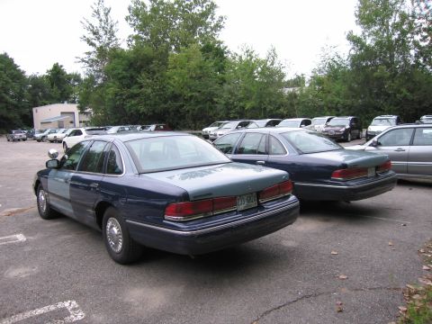 1991 Ford LTD Crown Victoria - Two Ford Crown Victorias are parked in a lot. The car in the foreground has a two-tone paint job.