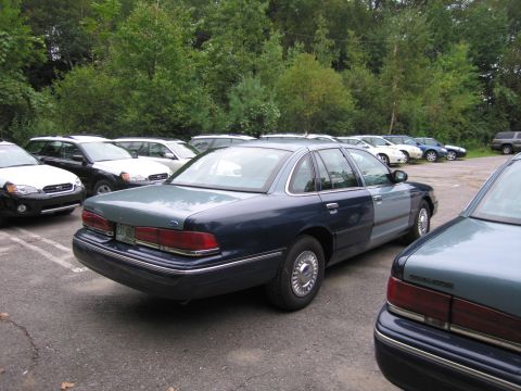 1991 Ford LTD Crown Victoria - A two-tone blue sedan is parked in a lot with other vehicles.