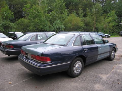 1991 Ford LTD Crown Victoria - Two Ford Crown Victorias are parked side-by-side, with the closest one showing a two-tone blue paint scheme.