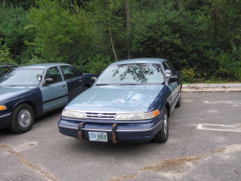 1991 Ford LTD Crown Victoria - A two-tone blue police car is parked next to another similar vehicle.