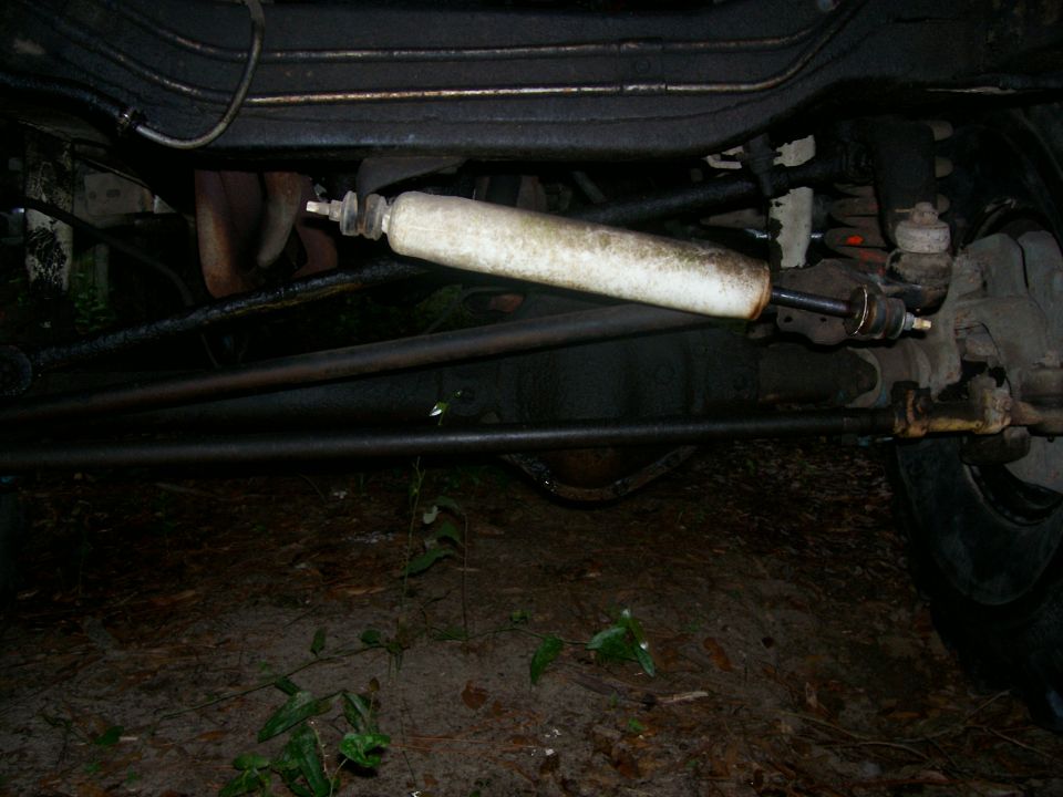 Close-up of a shock absorber and steering linkage on a vehicle's undercarriage