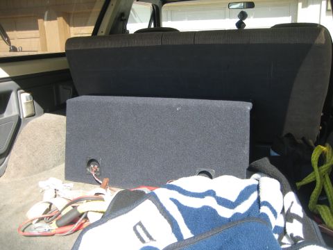 1989 Ford Bronco - Interior view of a vehicle's cargo area with a subwoofer box and blankets.