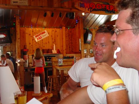 1986 Ford Mustang - A scene inside a Hooters restaurant shows a waitress behind the counter while patrons converse at a table.