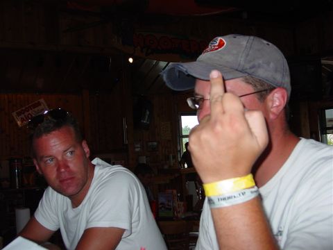1986 Ford Mustang - Two men are seen in a bar, one giving the middle finger gesture.