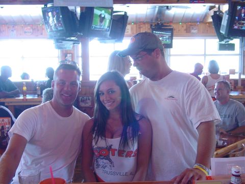 1986 Ford Mustang - A group of people are photographed together inside a Hooters restaurant.
