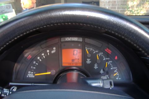 1994 Chevrolet Corvette - The dashboard of a car shows various gauges and a digital odometer reading zero.