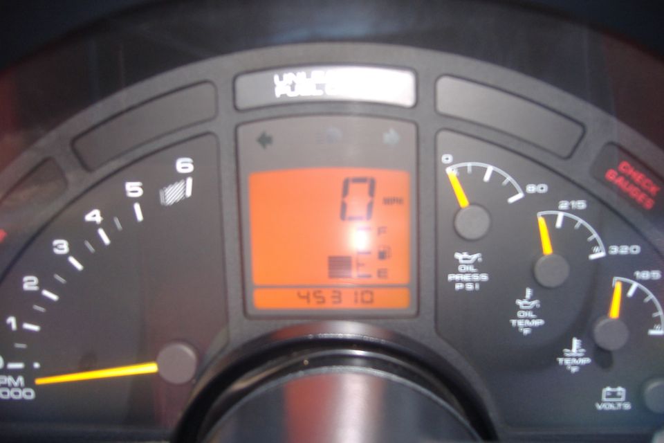 Car dashboard with tachometer, speedometer, oil pressure, oil temp, and water temp gauges. Digital odometer shows 45310