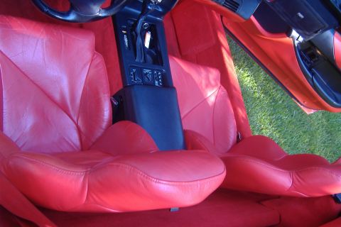 1994 Chevrolet Corvette - Interior view of a 1994 Chevrolet Corvette, showing the red leather seats and dashboard.