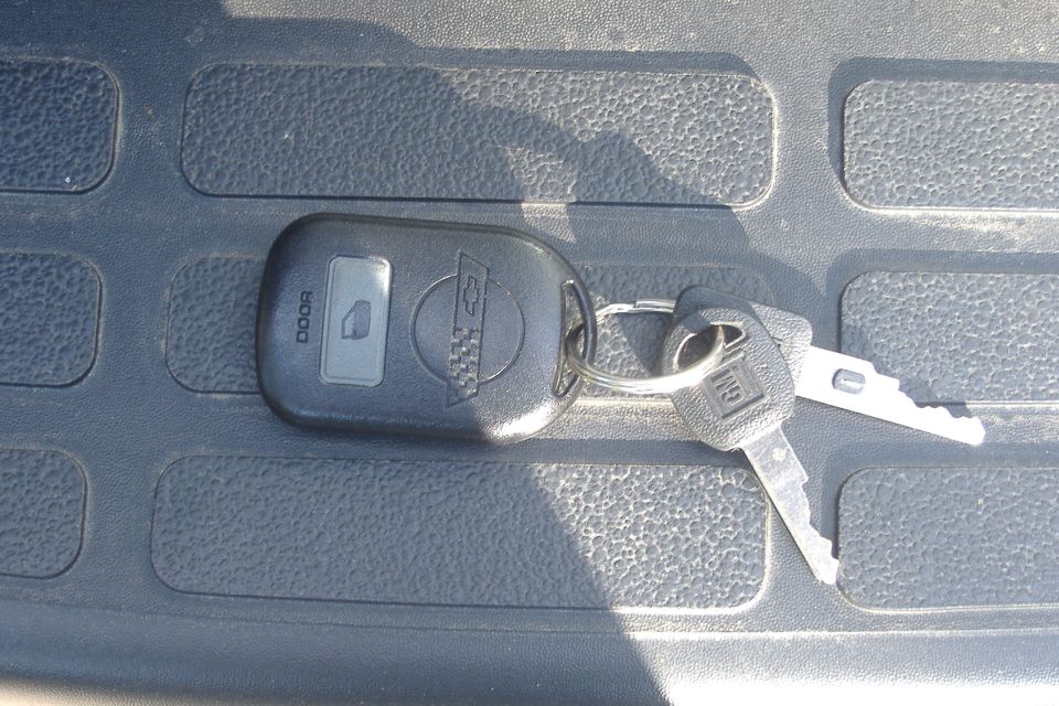 Car keys with Chevrolet and GM logos on textured surface
