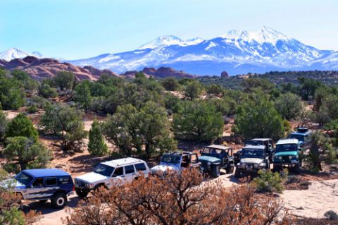 1997 Jeep TJ - A group of Jeeps are parked in a desert landscape with mountains in the distance.