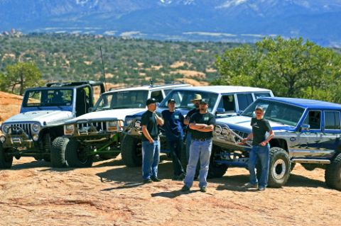 1997 Jeep TJ - A group of off-road enthusiasts pose with their customized Jeeps in a scenic, mountainous landscape.