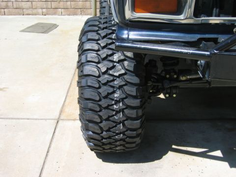 1985 Ford Bronco - Close-up of a modified Ford Bronco's front tire and suspension system.