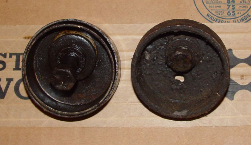 two rusty metal caps, each with a bolt in the center