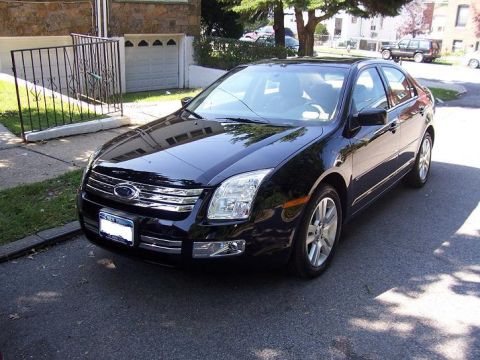 1999 Ford Crown Victoria - Front 3/4 view of a black sedan, appearing to be a 2006 Ford Fusion.
