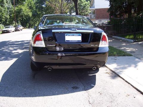 1999 Ford Crown Victoria - Rear view of a black Ford Fusion sedan parked on a residential street.