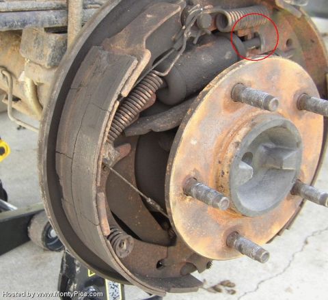 1979 Ford Bronco - Close-up of a vehicle's rear drum brake assembly, showing worn and cracked brake shoes.