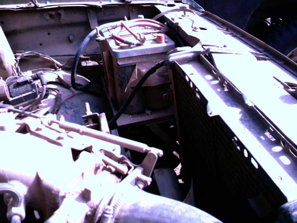 Engine bay showing two batteries, radiator, and engine components