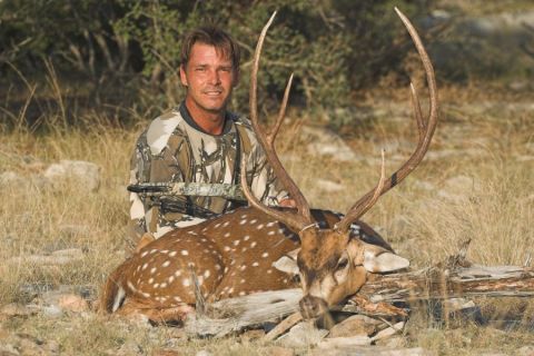 1986 Ford Bronco - Hunter poses with a spotted deer after a hunt, holding a bow.