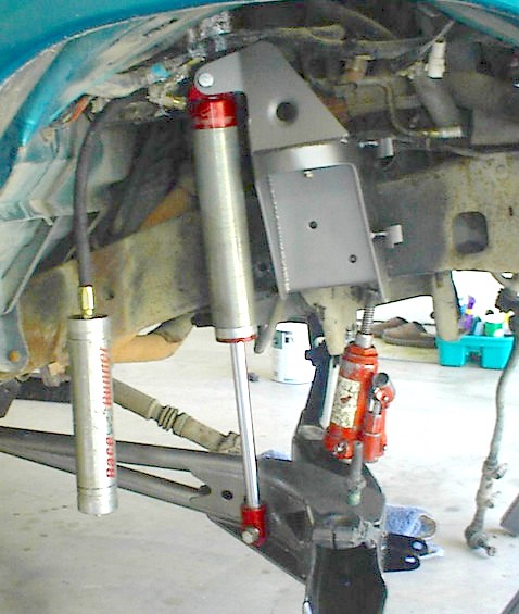 1984 Ford Bronco - Vehicle suspension components and a jack are visible in this close-up shot.