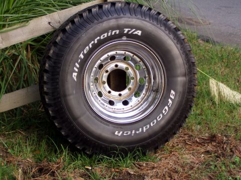1989 Ford F-250 - BFGoodrich All-Terrain T/A tire and chrome rim shown outdoors on grass.