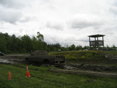 1978 Ford Bronco - A truck is stuck in the mud at an off-road park, with a cloudy sky overhead.