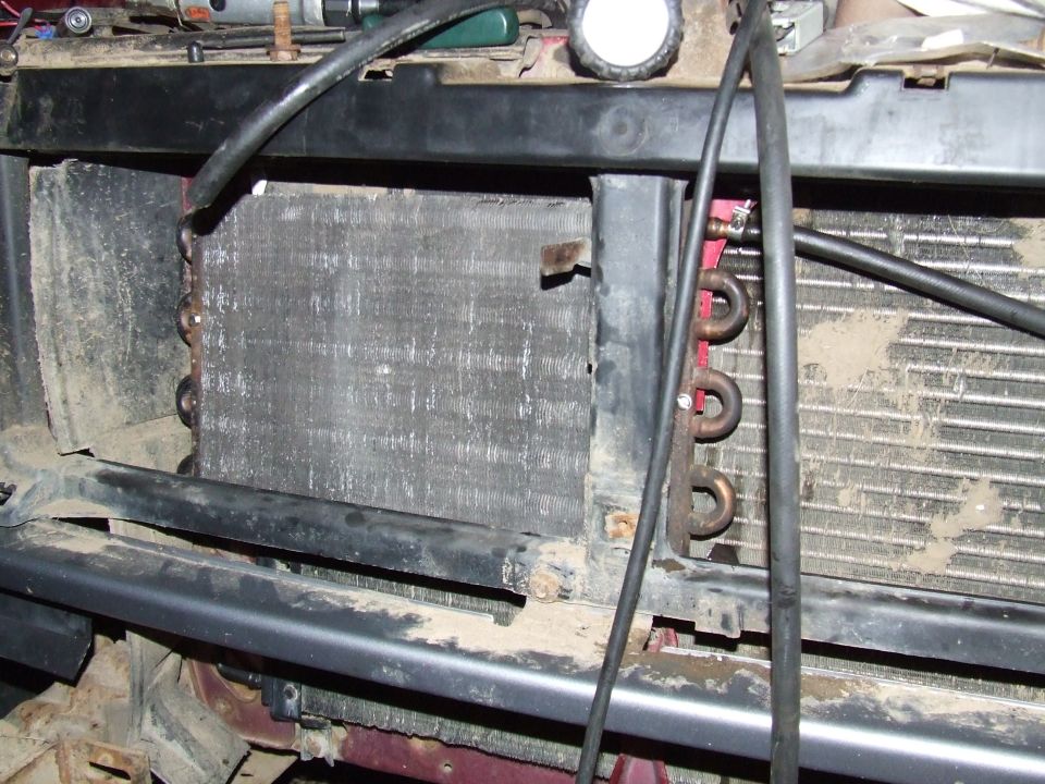 Dirty A/C condenser and oil cooler ahead of the radiator with grille removed on a truck