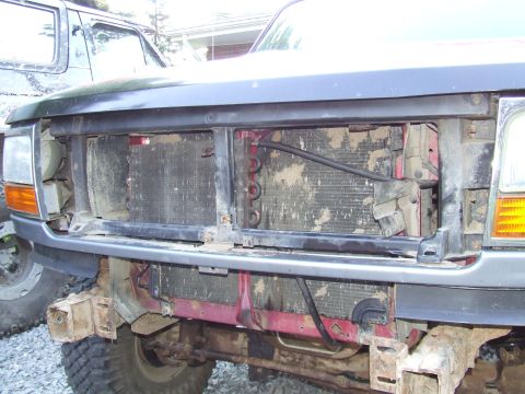 1995 Ford Bronco - The front end of a 1995 Ford Bronco, with the grille removed to expose the radiator and transmission cooler lines.