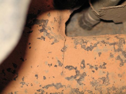 1995 Ford Bronco - Cracked exhaust pipe shows damage and peeling paint.